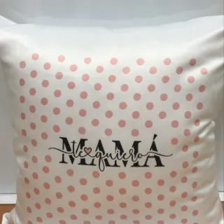 Cojín blanco con lunares rosas y el mensaje “MAMÁ te quiero” en el centro, en tipografía decorativa.